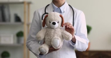 Hintli çocuk doktoru pofuduk bir gülümseme tutuyor. Kameraya bak.