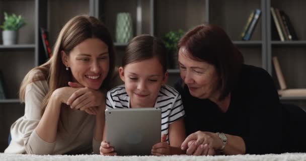 Счастливые три поколения женщин семьи с помощью цифрового планшета. — стоковое видео
