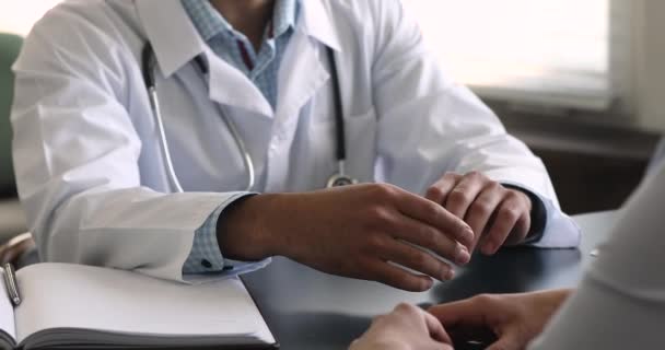 Doctorul african de sex masculin stă la masă consultând o pacientă de sex feminin — Videoclip de stoc