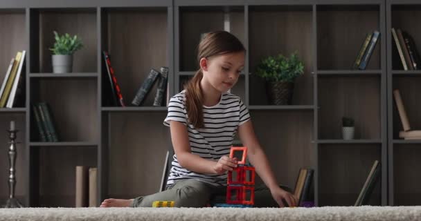 Concentrated happy girl playing toys alone at home. — Stock Video
