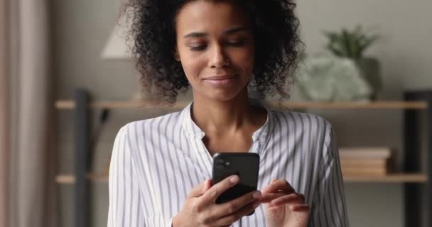 Joyeuse jeune femme afro-américaine utilisant un smartphone. — Video