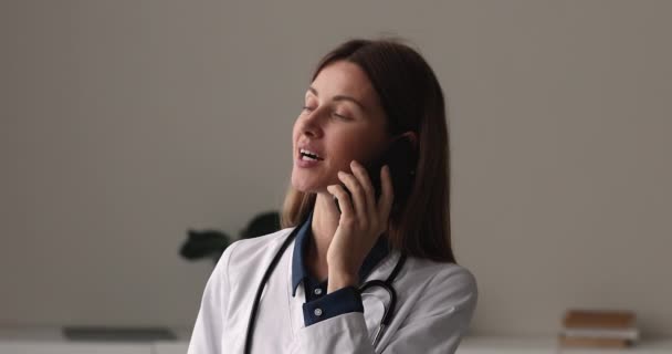 Mladé 30s ženské lékaře GP poradenství pacienta po telefonu. — Stock video