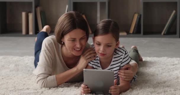 Bonding jovem mãe e pequena filha jogando tablet. — Vídeo de Stock