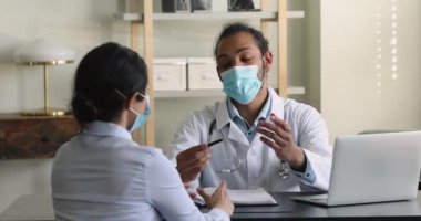Klinik ziyareti sırasında yüz maskesi takmış Afrikalı bir doktor.