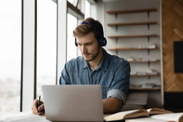 Focused adult student guy in headphones listening to learning seminar — Stock Photo, Image