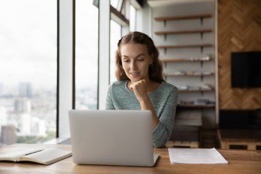 Bilgisayarı kullanan mutlu kadın çalışan, evden çalışıyor.