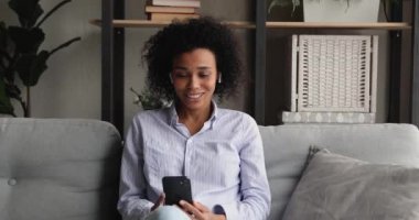 Gülümseyen güzel Afrikalı kadın, elinde video çağrısı tutuyor..