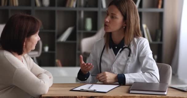 Jeune femme omnipraticienne consultant une patiente âgée. — Video