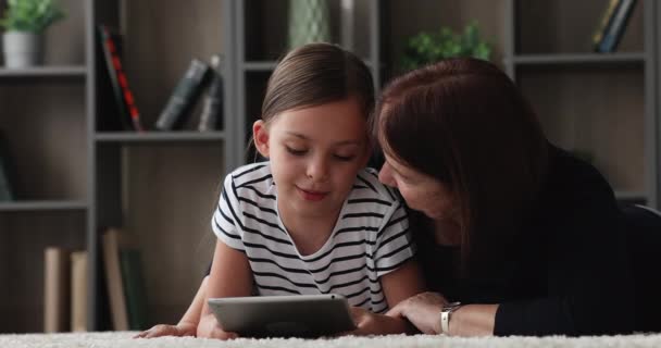 Velha avó feliz e menina pequena usando tablet. — Vídeo de Stock