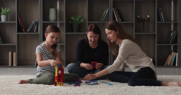 집에서 엄마와 할머니와 놀고 있는 미소짓는 어린 소녀. — 비디오