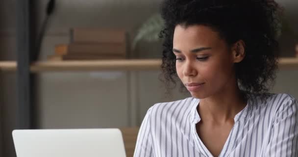 Pensiv ung afrikansk kvinna som arbetar med dator. — Stockvideo