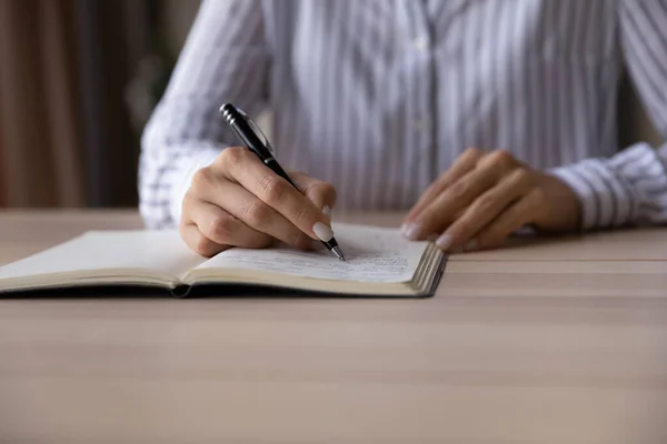 Close up of woman writing in stationary notepad — 图库照片