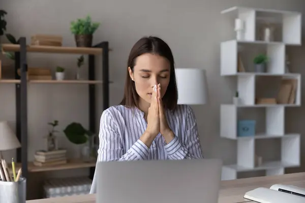 Superstitious young woman worker pray at workplace — Stock Photo, Image