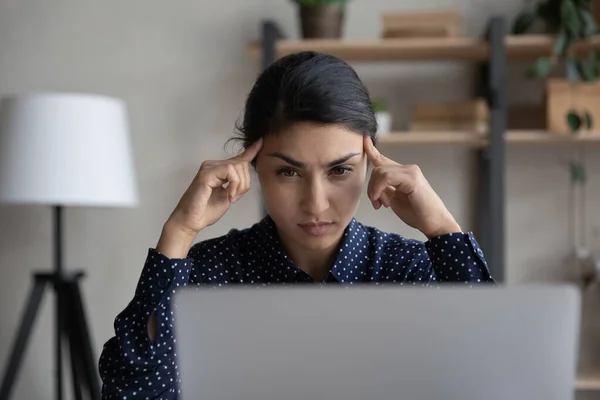 Pensive Indian kobieta patrzeć na laptop myślenia — Zdjęcie stockowe