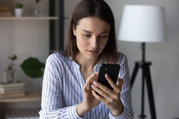 Young Caucasian woman use cellphone browsing internet — Stock Photo, Image