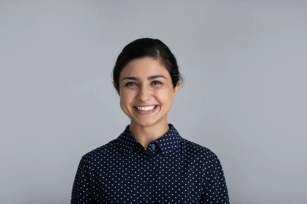 Headshot portret van lachende jonge Indiase vrouw op grijze achtergrond — Stockfoto