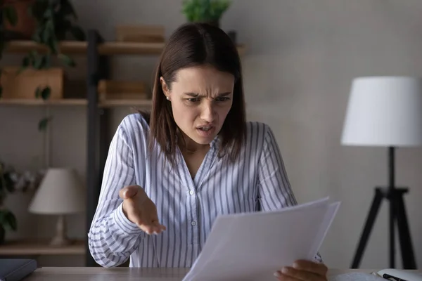Angry young woman distressed with news in paperwork — Foto de Stock