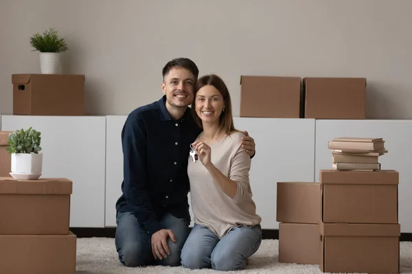 Young couple showing keys feel happy on moving day — Stockfoto