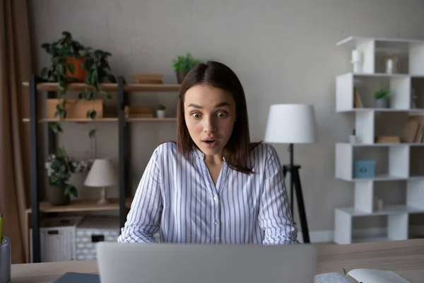 Mujer joven aturdido sorprendido por las noticias en el ordenador portátil — Foto de Stock