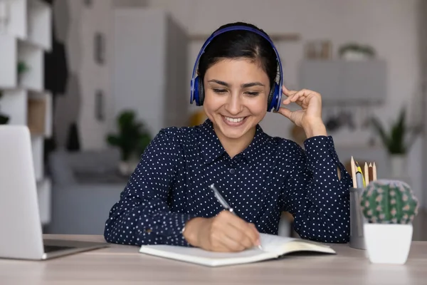 Smiling Indian female in headset study online on computer — стоковое фото