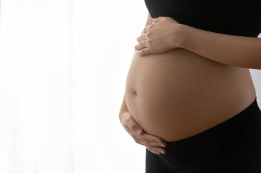 Genç yaşta anne dokunuyor ve kucağında kocaman bir yumru taşıyor.