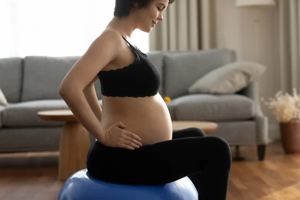 Happy young pregnant woman doing exercises with fitball at home — ストック写真