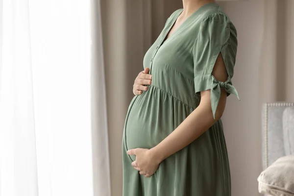 Expectant mother wearing dress for pregnant, holding big baby bump —  Fotos de Stock