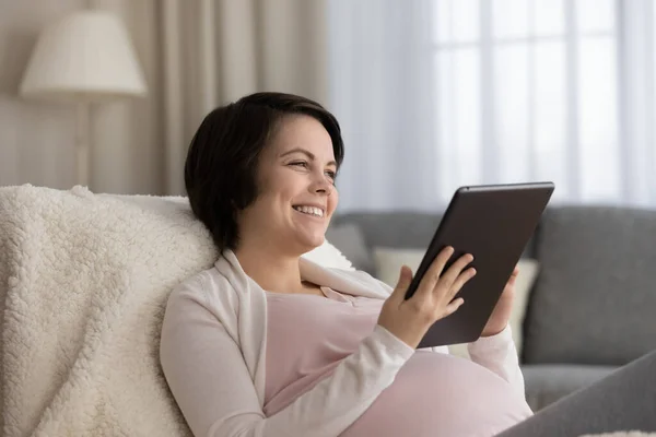 Happy young expecting mom enjoying leisure at home with gadget — Photo