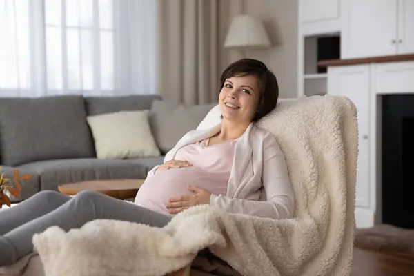 Portrait of happy young pregnant woman relaxing at home — Photo