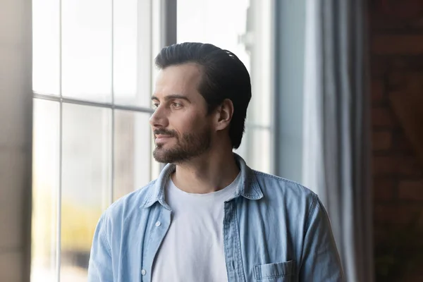 Pensive young man look in distance making plans