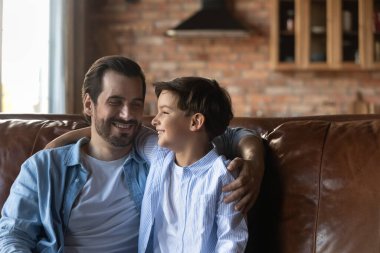 Smiling young father relax at home with small son