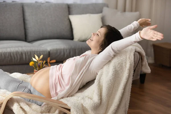 Smiling excited young pregnant woman relaxing at home — Stock Photo, Image