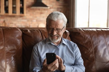 Happy old man talk on video call on smartphone