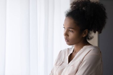 Unhappy ethnic woman look in distance thinking