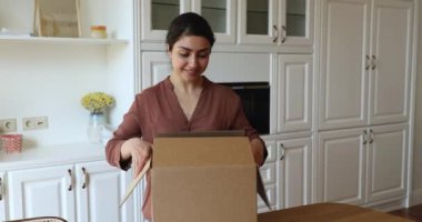 Indian woman unpack parcel box smile feels satisfied