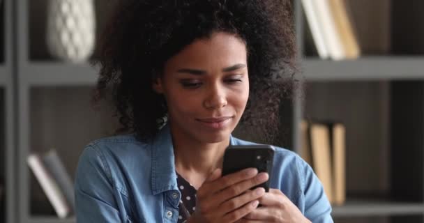 Smiling millennial african ethnicity woman using smartphone. — Video