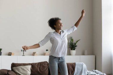 Overjoyed African American woman dance at home