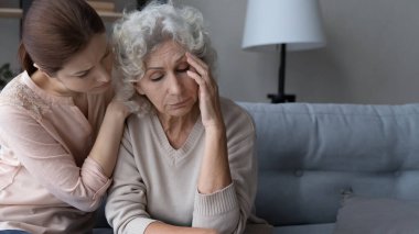 Caring grownup daughter support comfort upset old mother