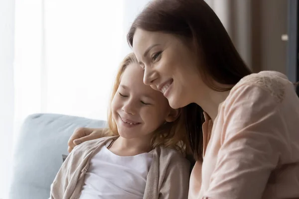 Smiling loving mom and small daughter relax cuddle — стоковое фото