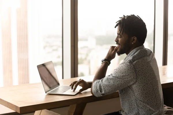 Afrikansk man som arbetar på laptop sitta i moderna coworking utrymme — Stockfoto