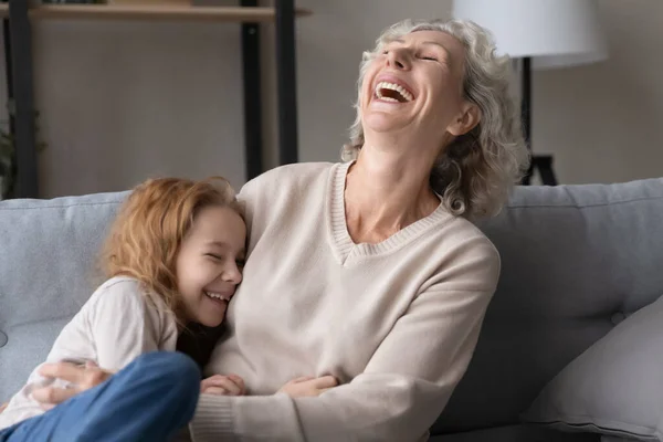 Smiling old grandmother and ten granddaughter laugh relaxing together —  Fotos de Stock