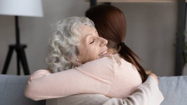 Happy senior mom and adult daughter hugging