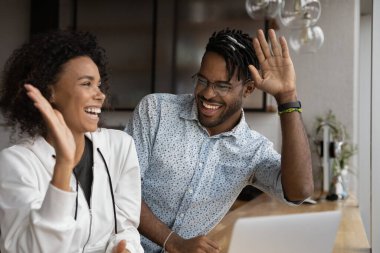 Happy African couple reading on laptop news giving high five
