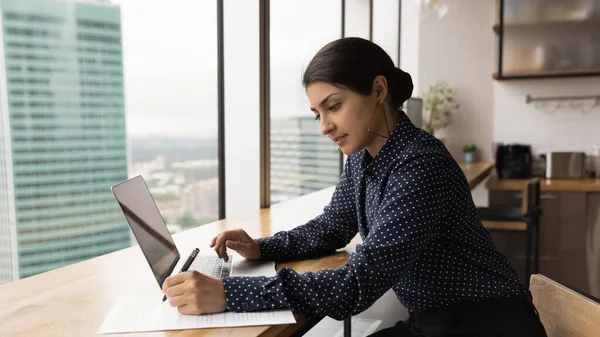 Indian woman working using laptop making corrections in document — Fotografia de Stock