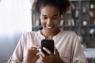 Happy African American woman use cellphone text online