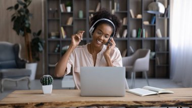 Happy African American woman listen to music in headphones