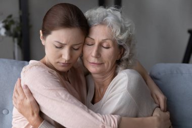 Loving daughter hug and comfort old upset mom