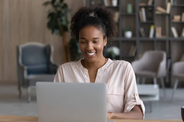 Glad afroamerikansk kvinna arbetar på bärbar dator online — Stockfoto