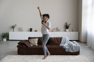 Smiling African American woman in earphones listen to music