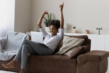 Overjoyed African American woman win lottery on laptop